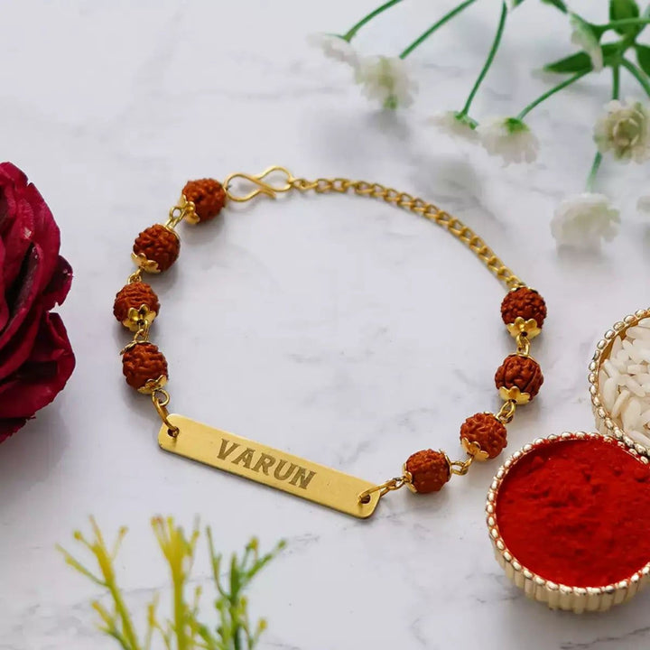 Handmade personalized Rudraksha Rakhi with brother's name engraved.